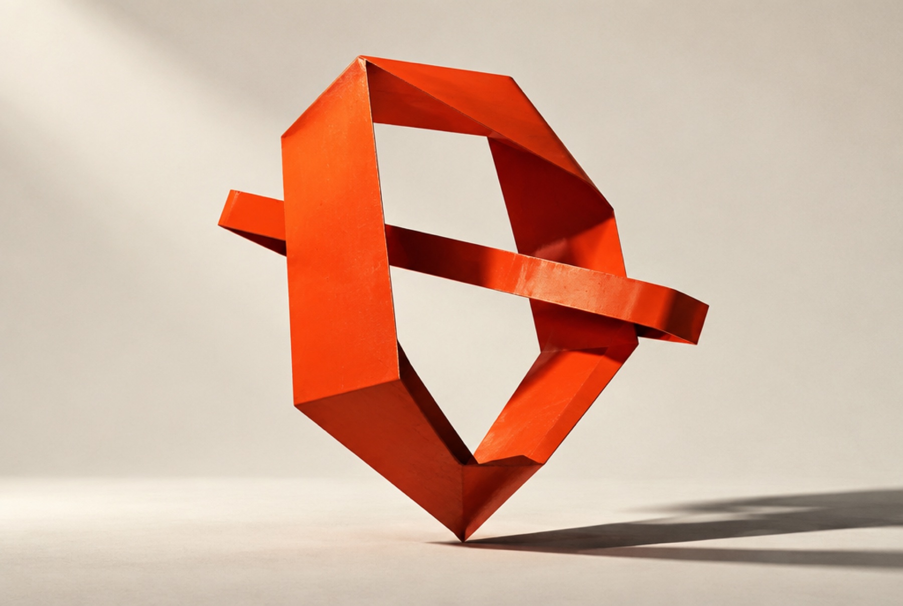Vermilion ribbon folded into an angular O, the Operopsy studio sculpture.